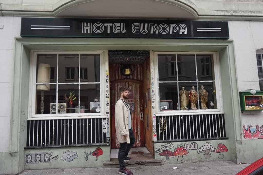 Chris steht vor einem der coolsten Clubs in Aachen, dem Hotel Europa